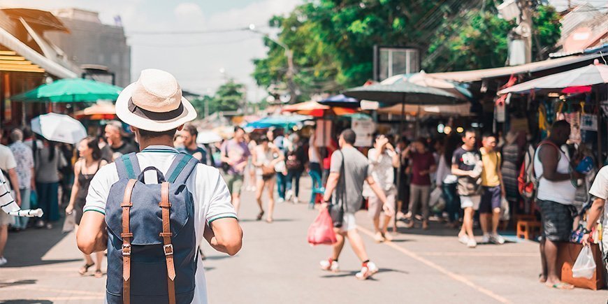 Mann som går på Chatuchak Weekend Market i Bangkok.