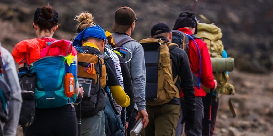 Vandrere som går på rekke og rad på Kilimanjaro