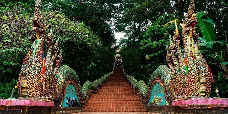 Trapper til Doi Suthep-tempelet i Chiang Mai, Thailand Munk ved Wat Phra That Doi Suthep-tempelet i Chiang Mai i Thailand Wat Chedi Luang-tempelet i Chiang Mai, Thailand Gatemat på nattmarkedet i Chiang Mai, Thailand Pagode i Doi Inthanon nasjonalpark i Chiang Mai, Thailand Båtseiling på elven Mae Ping i Chiang Mai, Thailand Bua Tong Sticky-fossen i Chiang Mai, Thailand Elefant i ChangChill i Chiang Mai