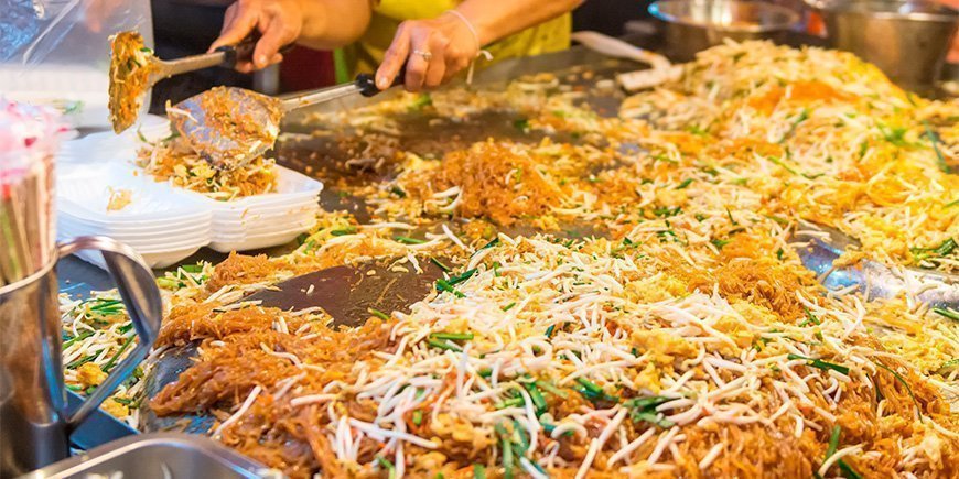 Pad Thai tilberedes ved en gatematbod i Thailand