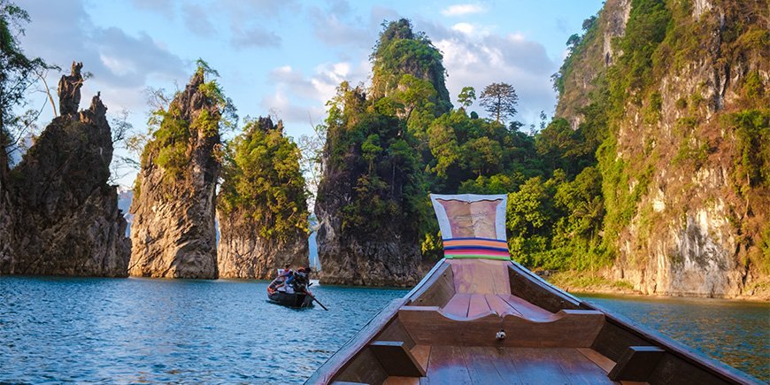 Båt seiler på innsjøen i Khao Sok nasjonalpark