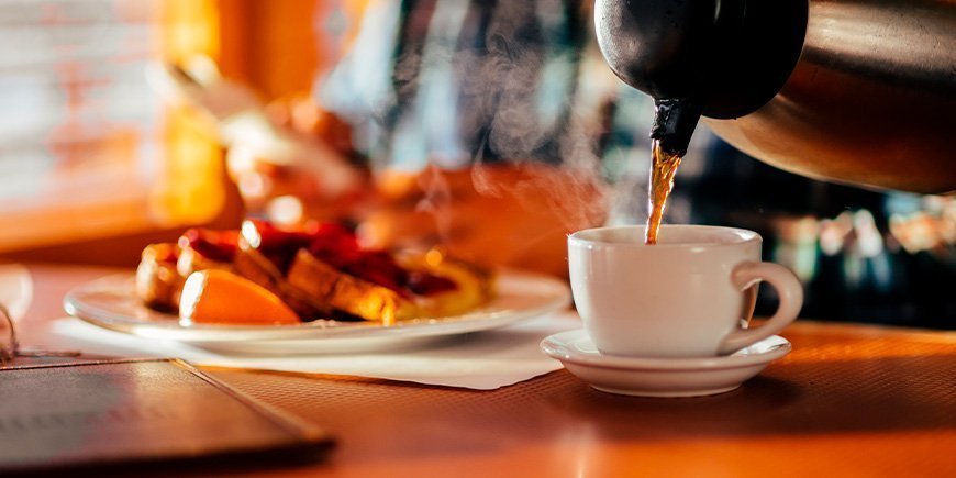 Mann sitter på en diner og spiser vafler og drikker kaffe