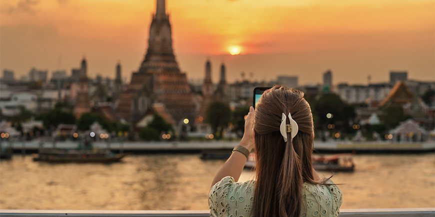 Kvinne tar bilde av Wat Arun i Bangkok