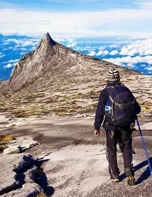 Mann på trekking på Mount Kinabalu i Malaysia