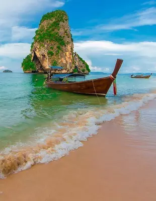 Longtailbåter under blå himmel på stranden i Krabi, Thailand
